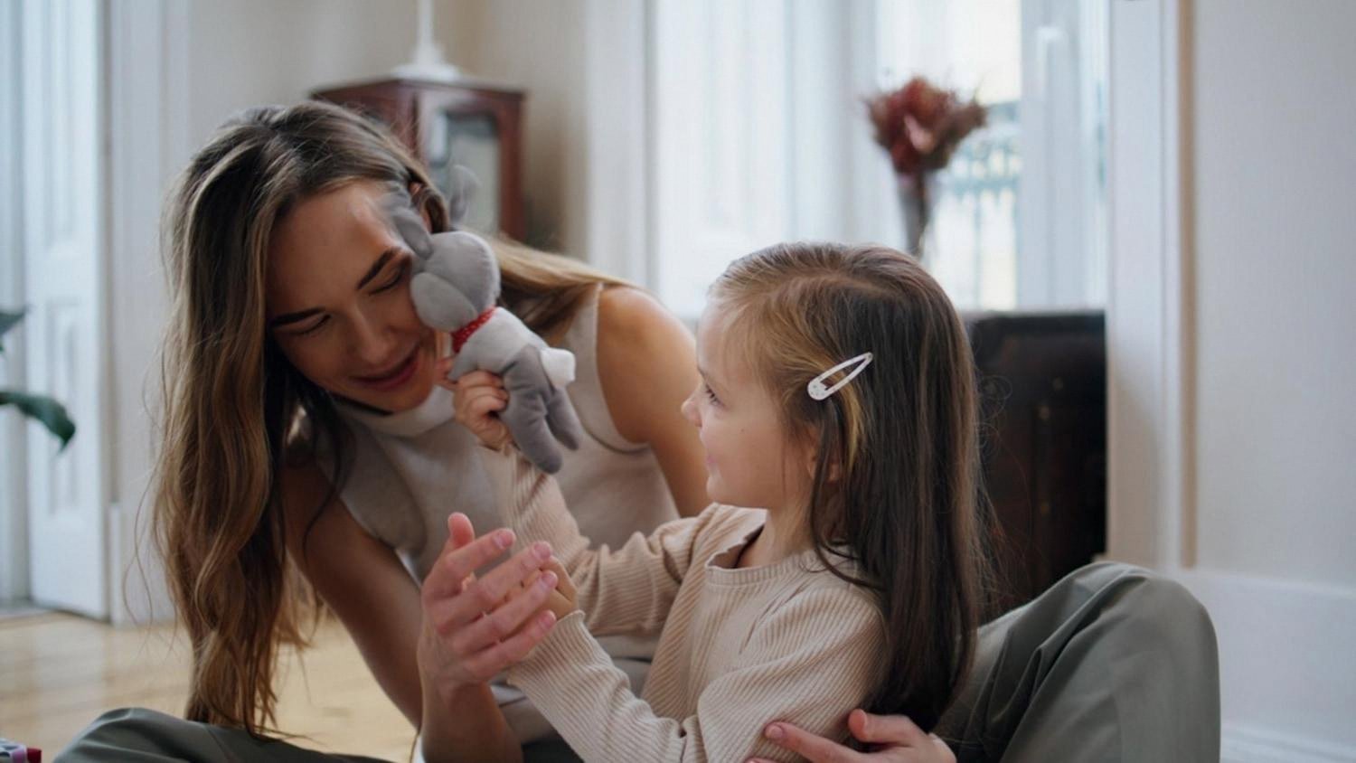 Mother and daughter enjoying an eco-friendly plush toy together at home in Dubai